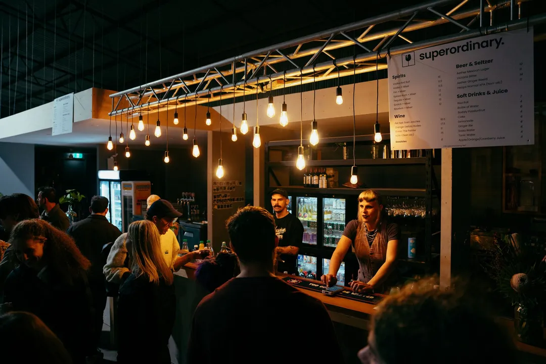 The Superordinary bar under festoon lights as the crowd arrives