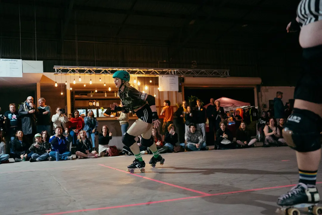 A skater rounds the track past the bar and the seated crowd