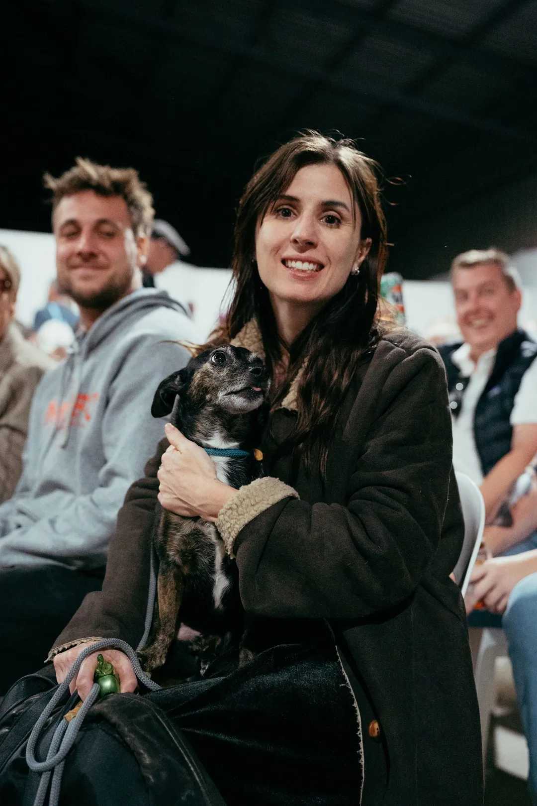 Two spectators and their dog in the front row